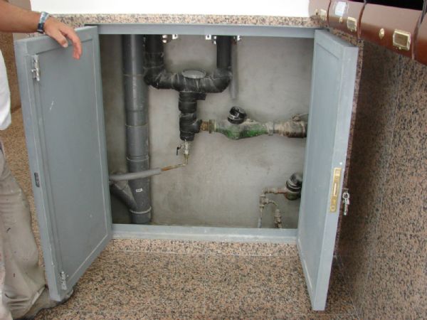 El interior del armario de contadores de agua, con las puertas de acero