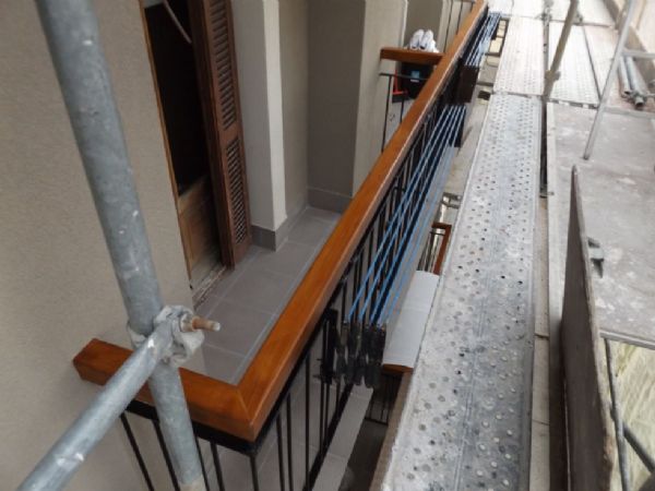 Detalle balcones terminados, con nuevos pasamanos de madera, barandillas esmaltadas y suelos alicatados