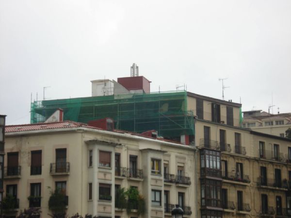 el montaje del andamiaje en la fachada lateral izquierda, sobre la cubierta del edificio colindante