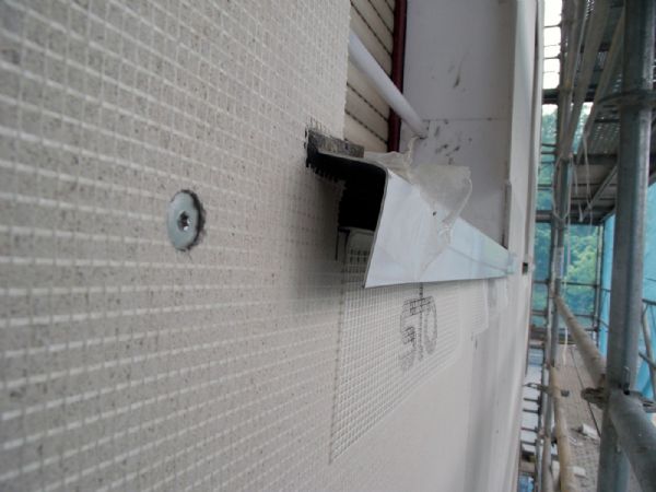 Detalle de un alfeizar, en la fachada ventilada, donde se observa; la cinta de juntas en la unión con el aluminio y el hueco para ventilación bajo el alfeizar.