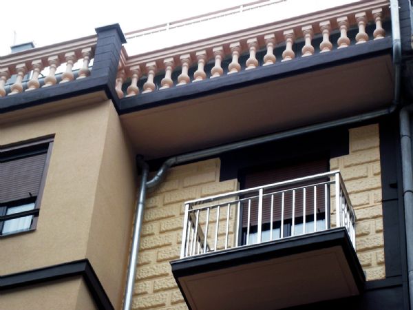 En la fachada principal, detalle de las barandillas en acero inoxidable, las bajantes de zinc, la pared que tiene imitacin piedra solo se ha pintado y la pared del mirador se ha aislado con sistema SATE.