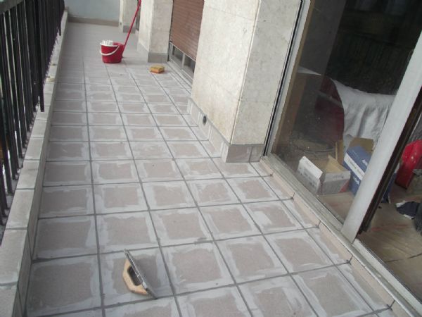 Despus de colocadas las dos telas, incluso sobre el murete bajo la barandilla, se protegi con geotextil, se verti una capa de mortero con malla y se coloc gres porcelanico. En la imagen el rejunteo del gres.