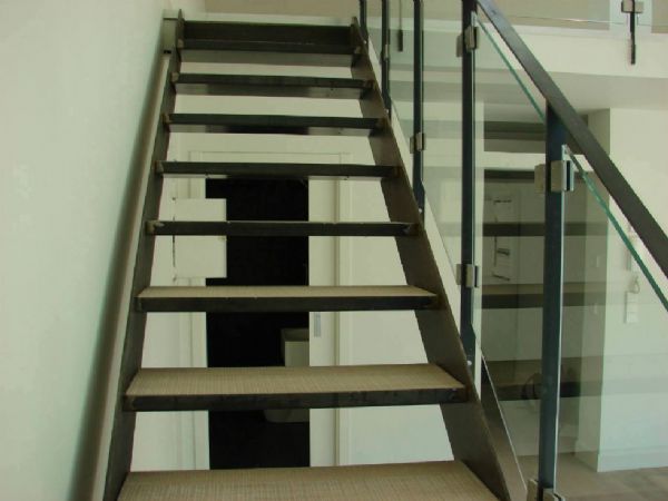 Detalle de la escalera realizada en hierro, con los escalones rellenos con el mismo parquet que se colocó en el resto del suelo