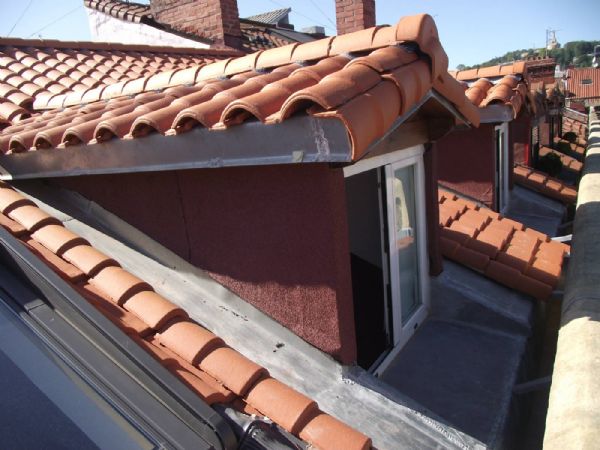 Las buhardillas terminadas, con los cantos del alero forrados de zinc, las paredes forradas con tela asfltica con acabado mineral y todo el permetro de la buhardilla forrada de zinc, incluida la encimera delante de la ventana. Sobre la ventana se dej un alero en madera y se colocaron ventanas en aluminio rotura de puente trmico