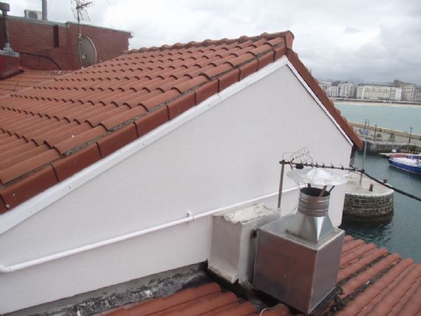 La fachada lateral terminada, donde se observa el remate de aluminio entre el SATE y la teja