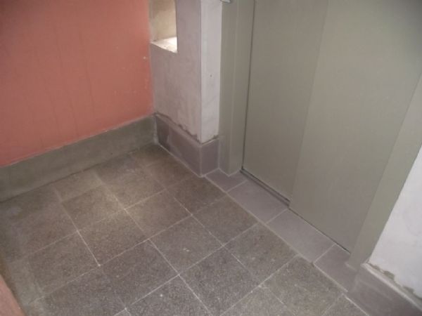 El suelo de accesos en entreplantas, donde solo se ha sustituido una hilera de plaqueta en encuentro con la puerta de ascensor