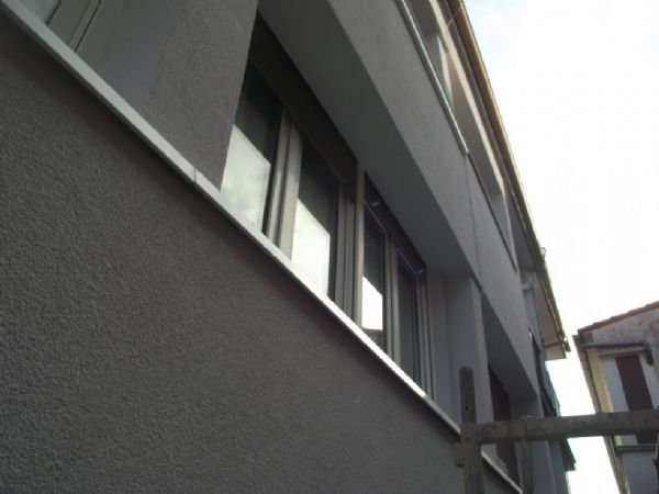 Detalle de la fachada terminada, mortero acrilico aplicado, alfeizares en aluminio blanco 1