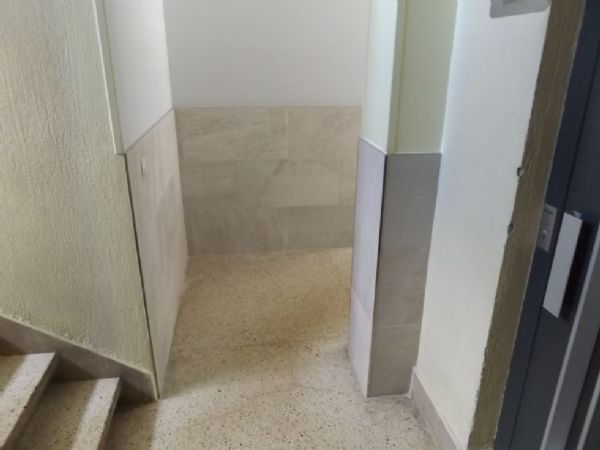 Fin de obra. Encuentro entre zona de portal renovada y zona de caja de escaleras que no se modifica